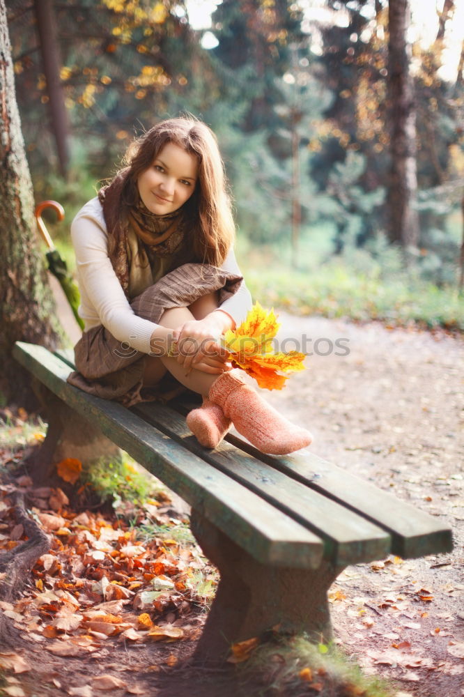 Similar – side portrait of young woman in summer dress sitting barefoot between bushes in nature