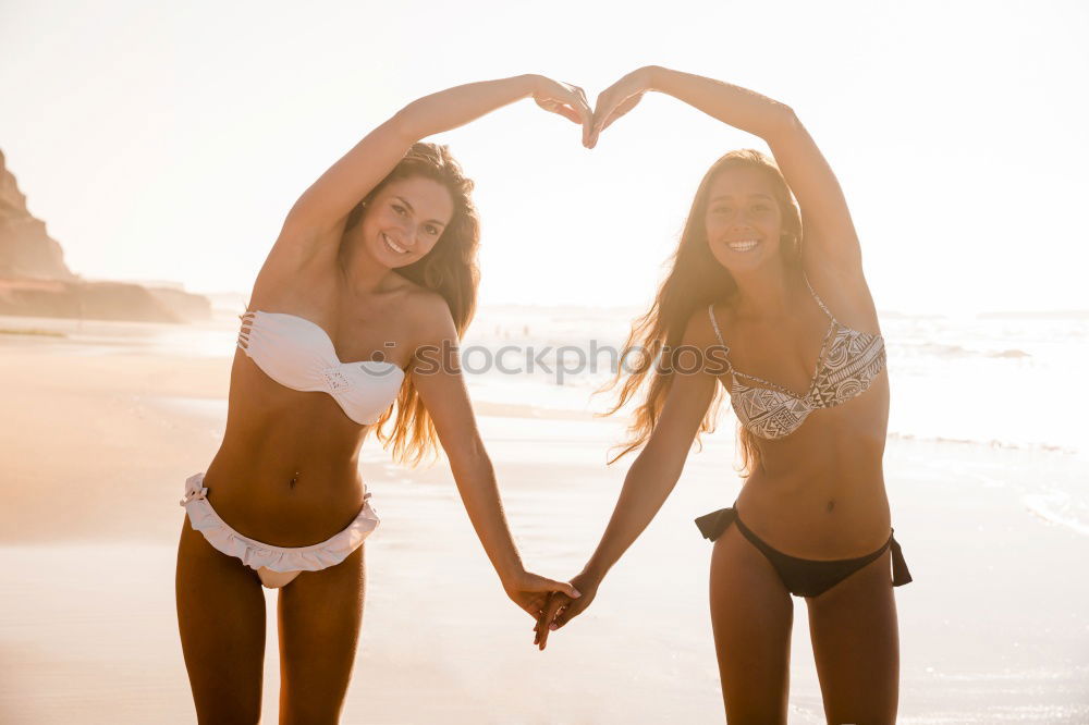 Similar – Image, Stock Photo Two young adult girlfriends chatting at beach and laughing