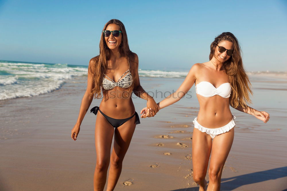 Similar – Zwei Frauen im Bikini, die auf einem tropischen Strandsand sitzen.