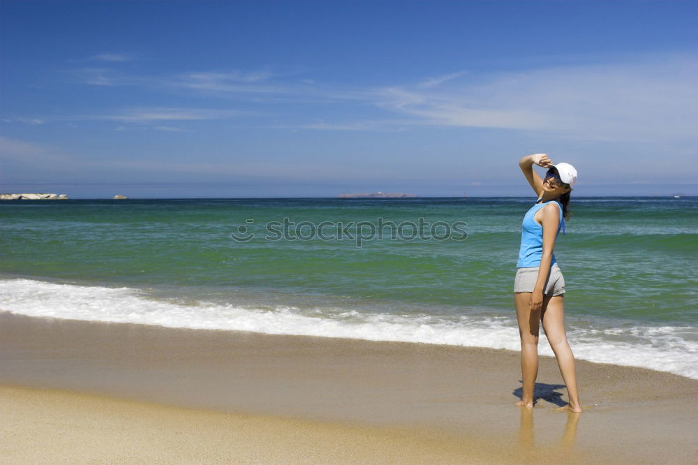 Woman with blue dress and hat at Malecon in Havana