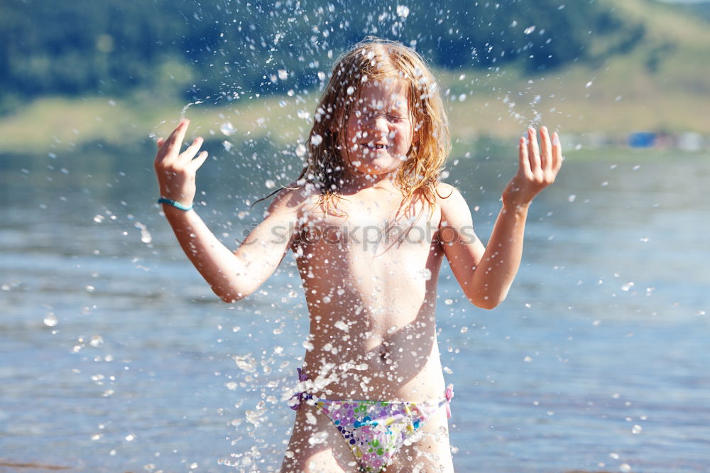 Playful girl standing in pier near lake