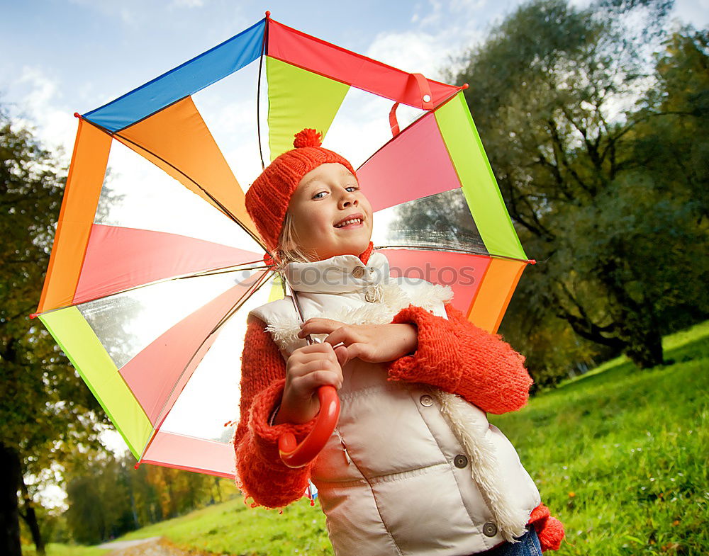 happy kid girl hiding under umbrella