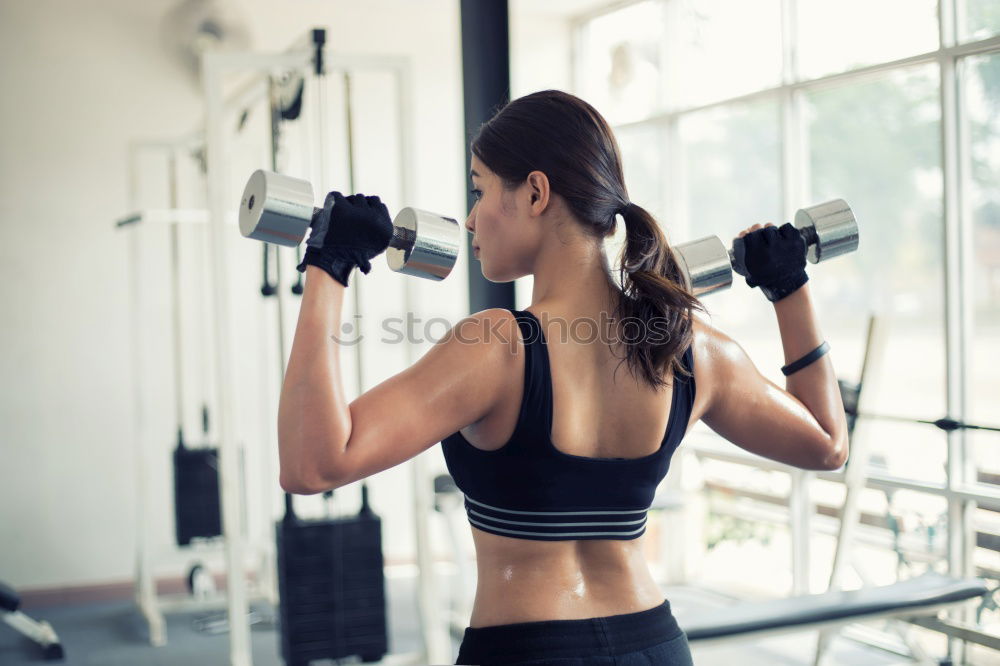 Similar – Sporty woman sitting with dumbbells and smartphone in gym floor