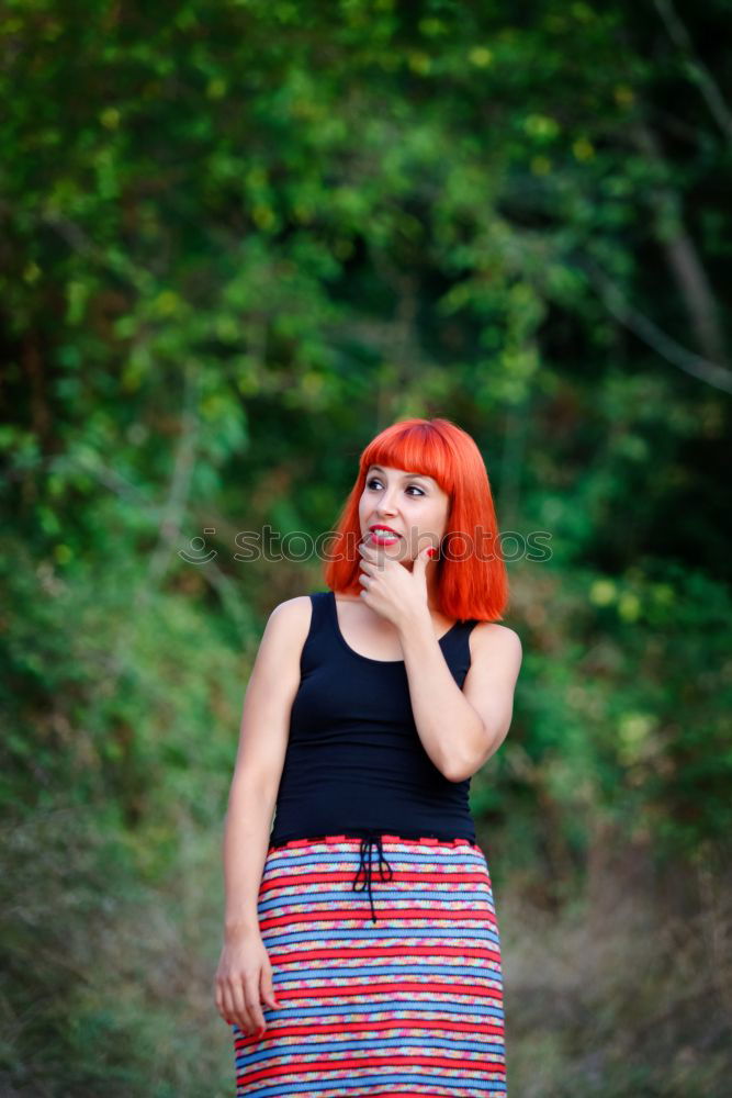 Similar – Redhead woman smelling a flower in a park