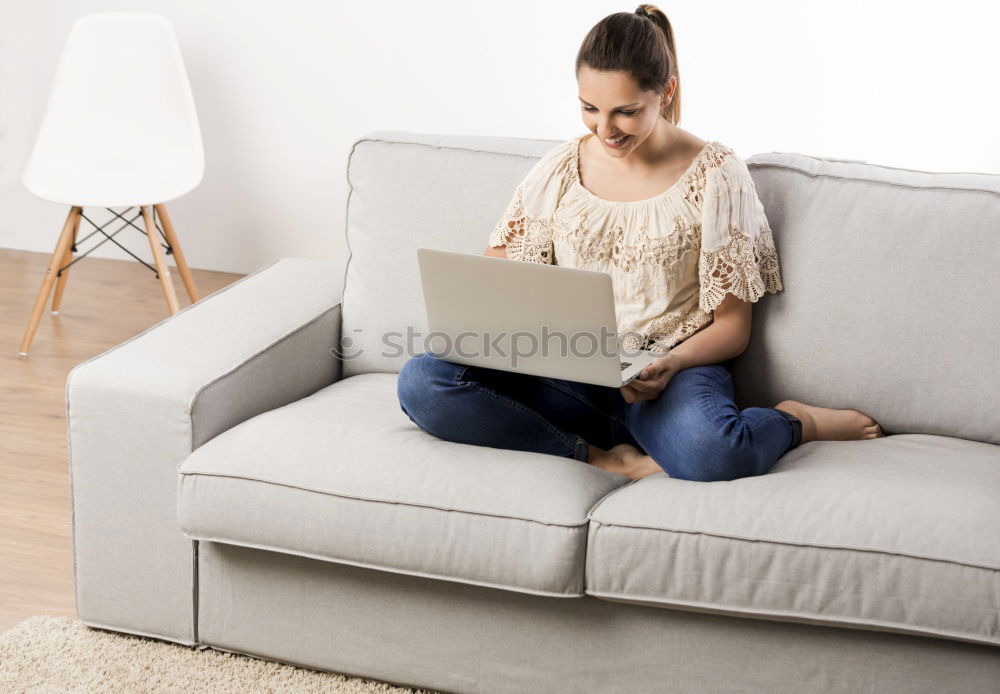 woman with laptop on her sofa at home