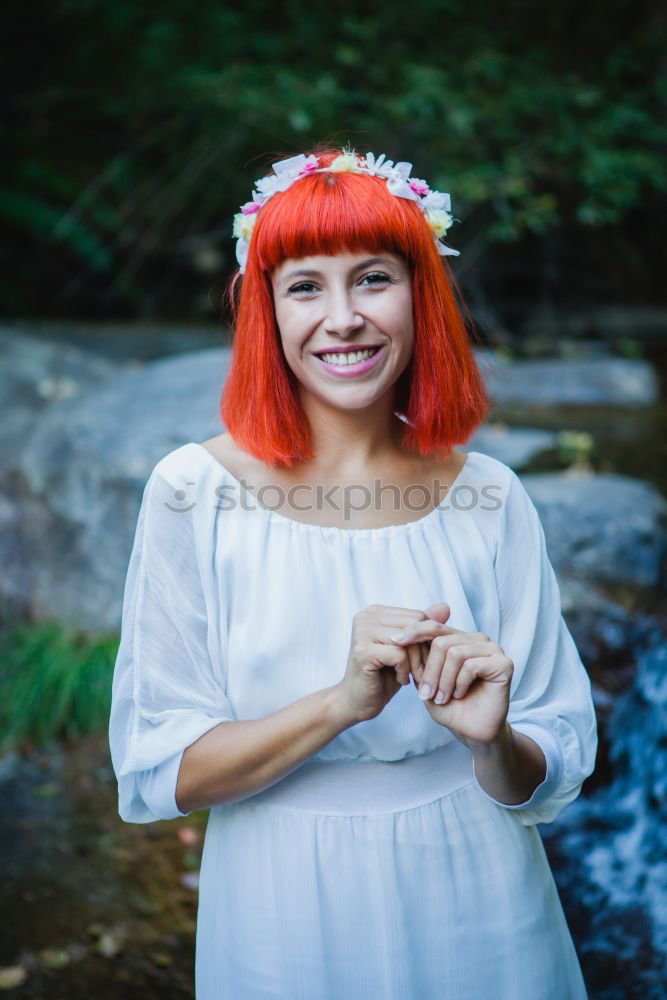 Similar – Redhead woman smelling a flower in a park