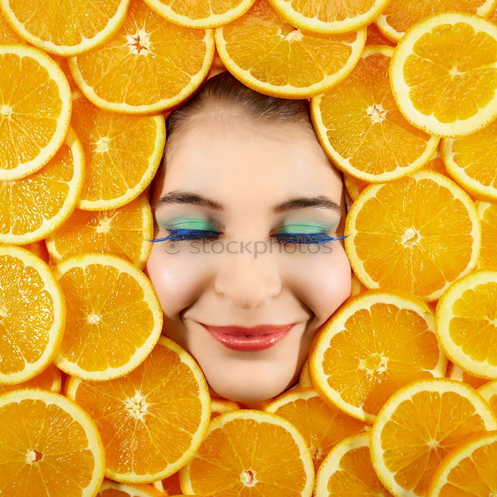 Smiling woman between slices of orange