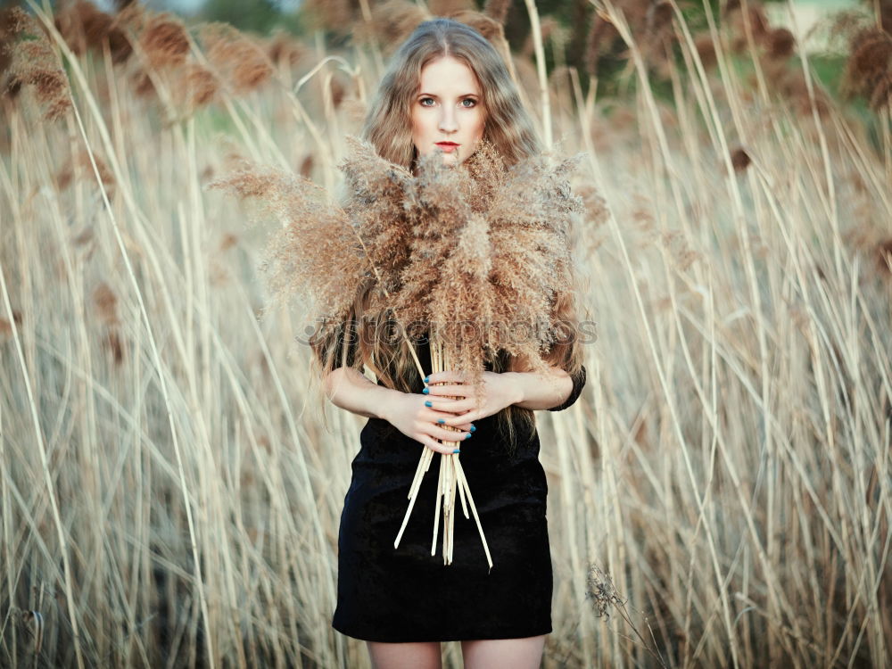 Similar – Young woman observing weird flowers