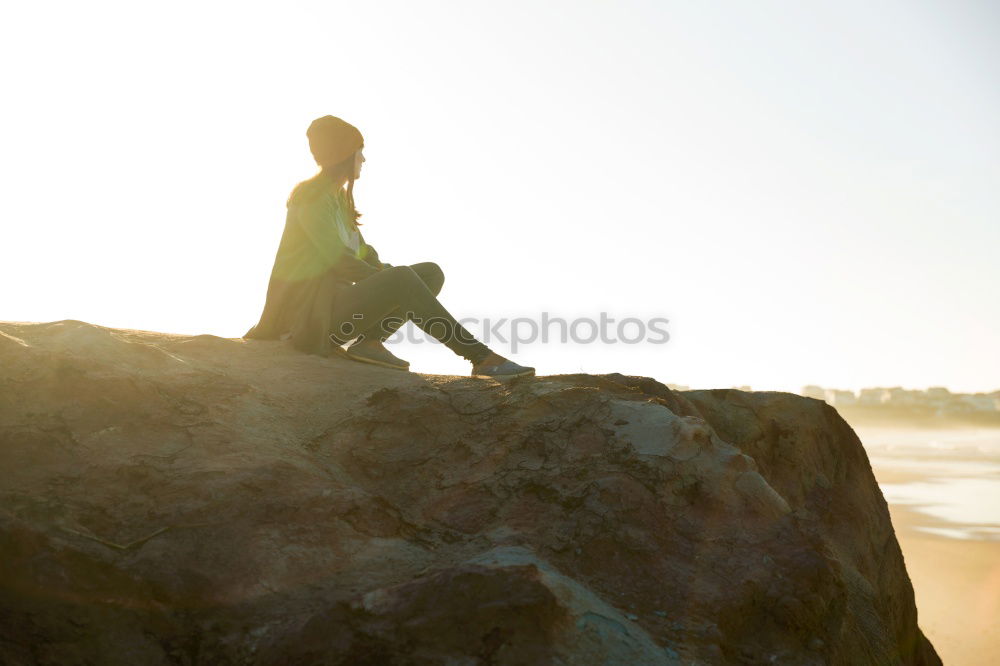 Similar – Man sitting on fence in rocky coast