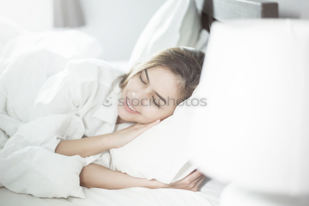 Image, Stock Photo A young smiling beautiful girl is lying in bed in the bedroom. The girl stretches in the morning after waking up. Side view, space for text