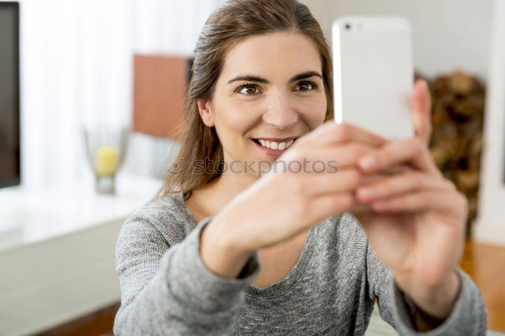 Similar – Young happy woman with green jacket taking selfie with her smartphone on the beach at sunset