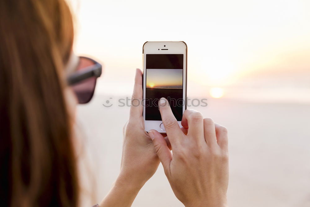 Similar – Image, Stock Photo Young woman is holding smartphone in her hands at the beach