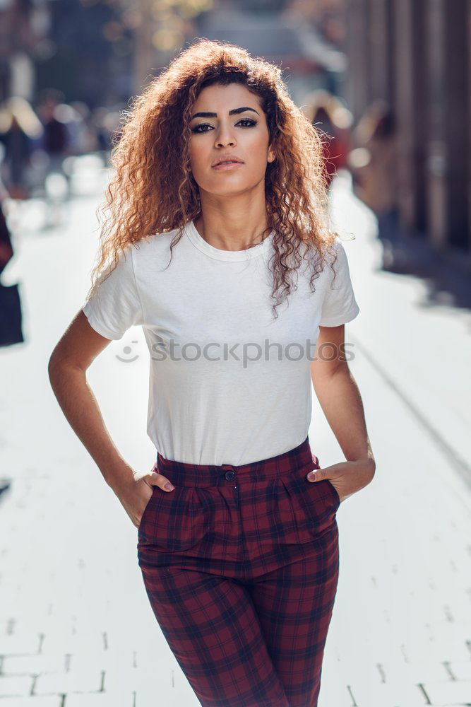 Smiling young Arab woman with black curly hairstyle