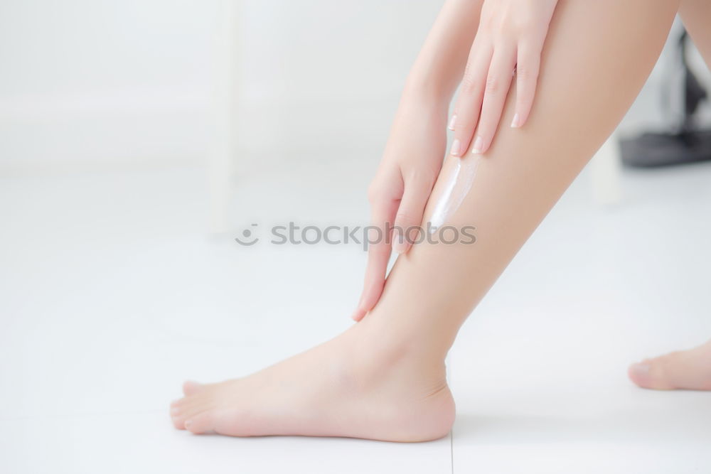 Similar – Above shot of white woman holding her legs in shoes