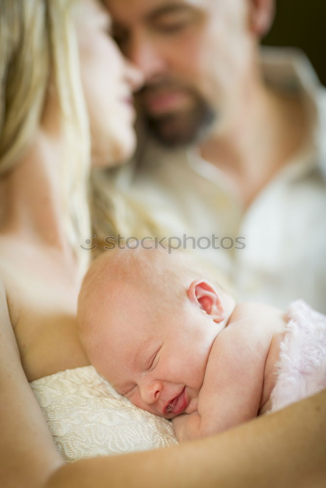 Similar – Image, Stock Photo Couple embracing and looking to their newborn over dark background