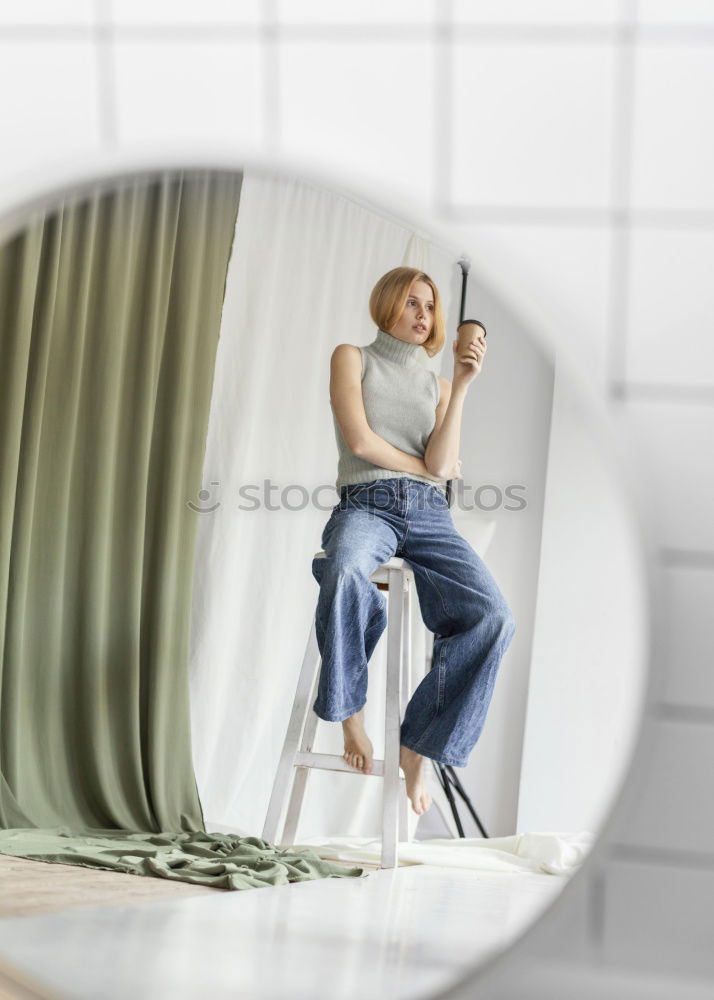 Similar – Young woman sits on the couch and sticks out one leg