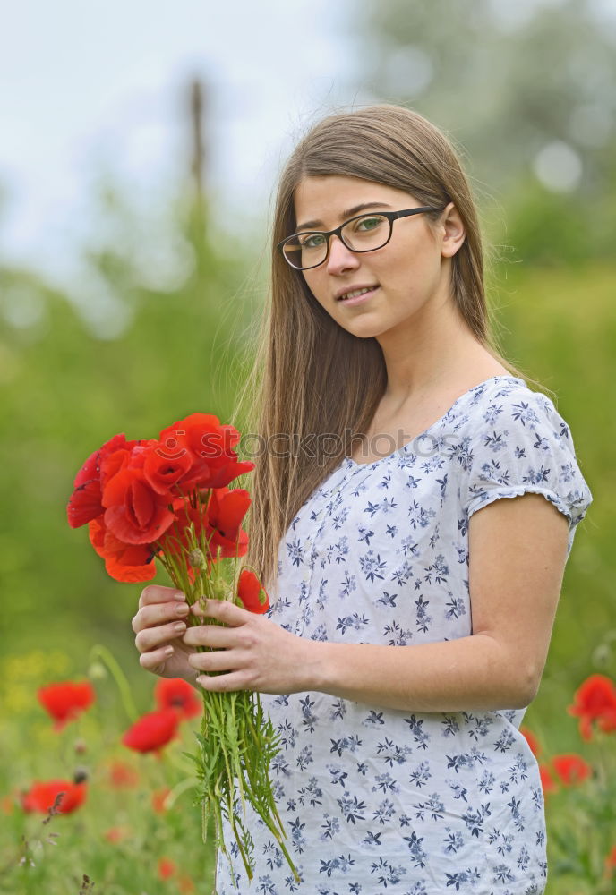 Similar – Redhead woman smelling a flower in a park