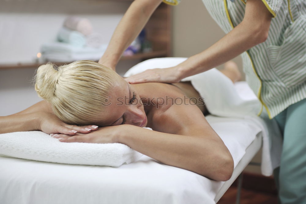 Similar – Woman at beauty spa getting a procedure with hot stones while massage therapist doing arm massage