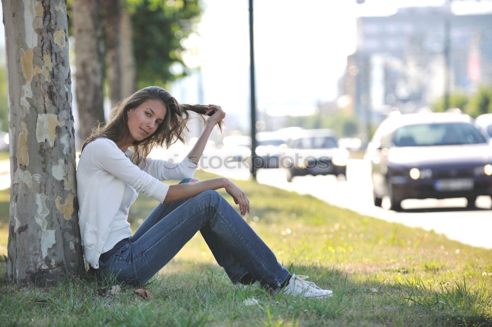 Similar – thoughtful woman with dreadlocks, in jeans and brown leather jacket is standing at an old dilapidated house wall