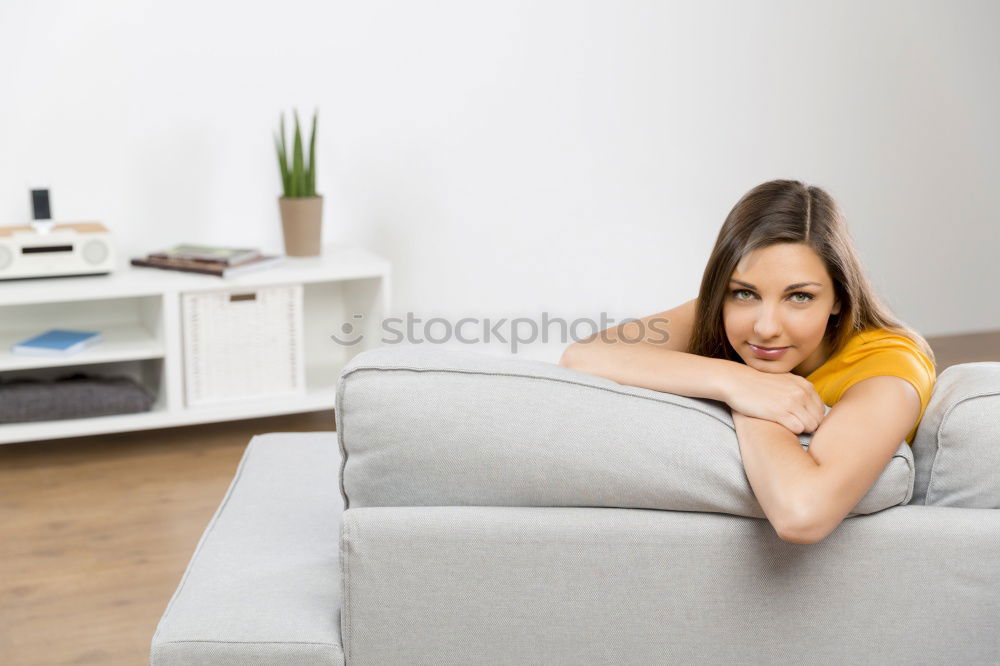 young tall woman sits on a light couch