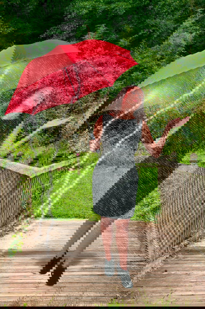 Similar – Image, Stock Photo A long haired blonde woman ducks under red umbrella in rainy weather