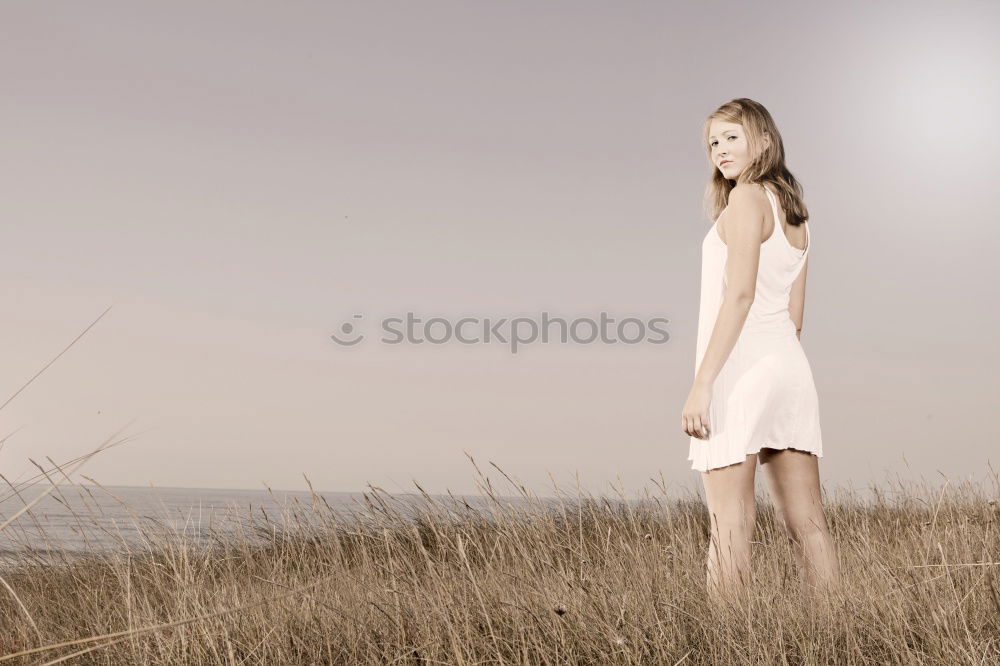 analogue portrait of a young woman standing barefoot in a glass greenhouse