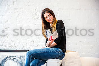 Similar – Image, Stock Photo Young woman using an smartphone and listening music while lying on a leather couch