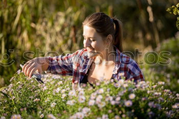 Similar – Image, Stock Photo Woman dressed in red sitting on a meadow and looking for something in her handbag