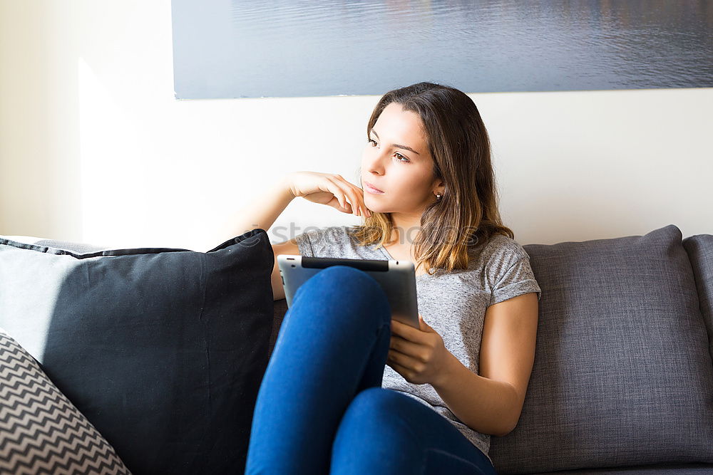 Similar – Image, Stock Photo Young woman using an smartphone and listening music while lying on a leather couch