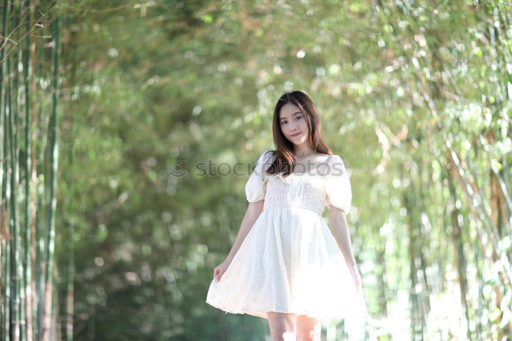 Similar – Image, Stock Photo Woman with long brunette waving hair and pink dress dancing barefoot on a large paved square against the light