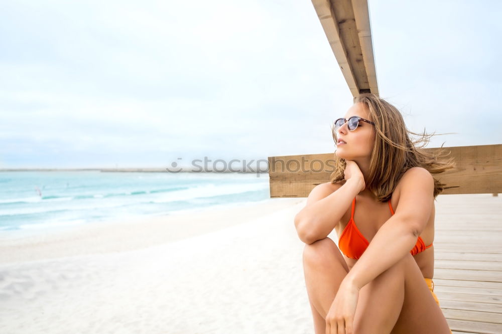 Similar – Beautiful girl lying at the beach in her swimsuit and reading a book