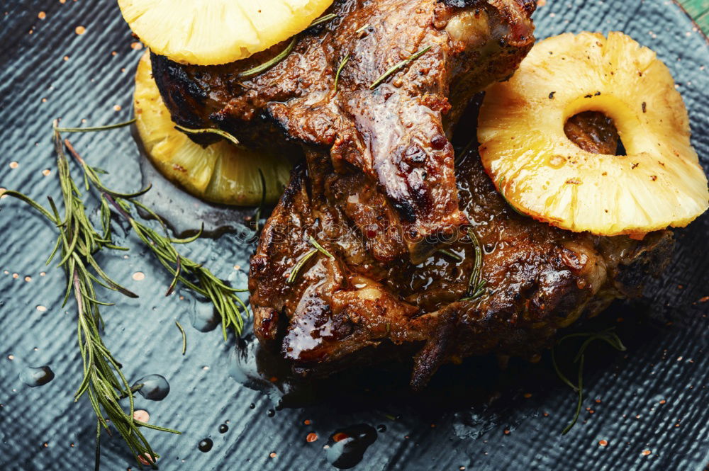 Fleisch vom Grill mit Ananasringen.