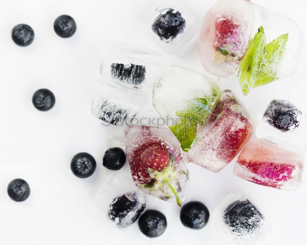 Similar – Berry-fruity water, iced with raspberries, blueberries, ice cubes and drinking straw on white background