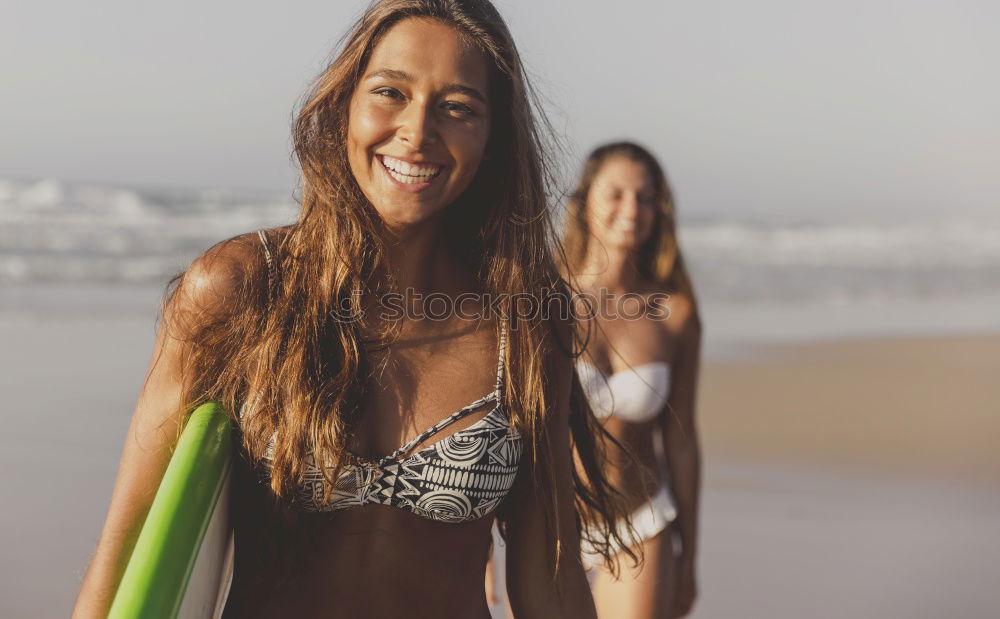 Similar – Image, Stock Photo Two happy girlfriends having fun at the beach with surfboards