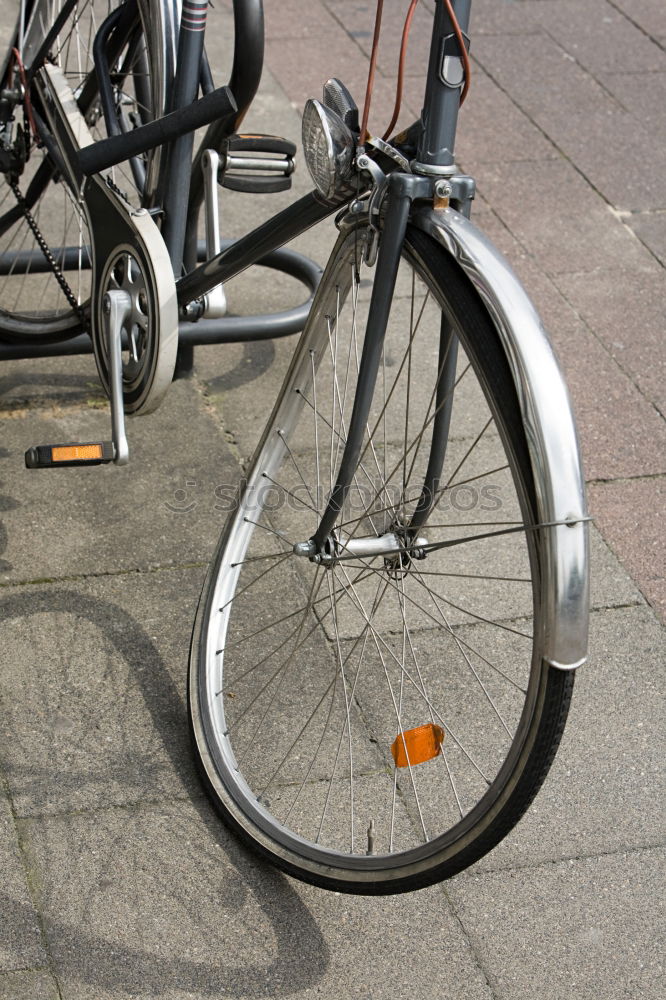 Only the front wheel of the bicycle is still properly chained in the bicycle stand. Bicycle theft