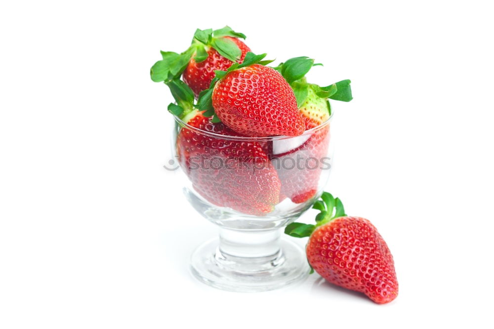 Pink sweet lemonade made of raspberry juice with frosted blackberries and strawberry blossom in a glass with sugar rim and drinking straw on striped tablecloth