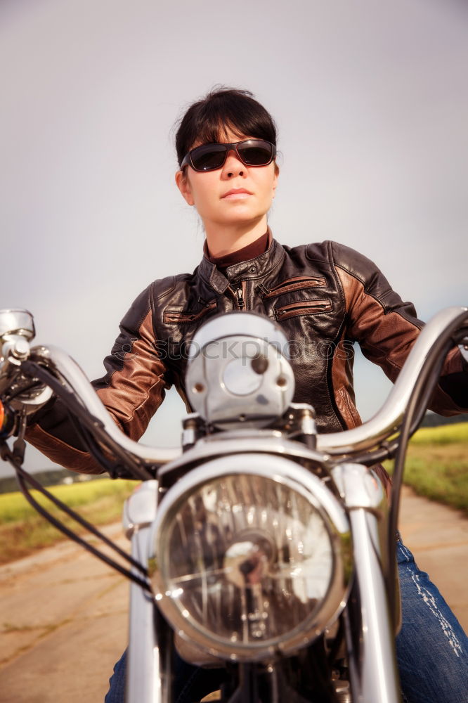 Similar – Long-haired brunette guy in sunglasses jeans and a jeans shirt posing on a black custom motorcycle