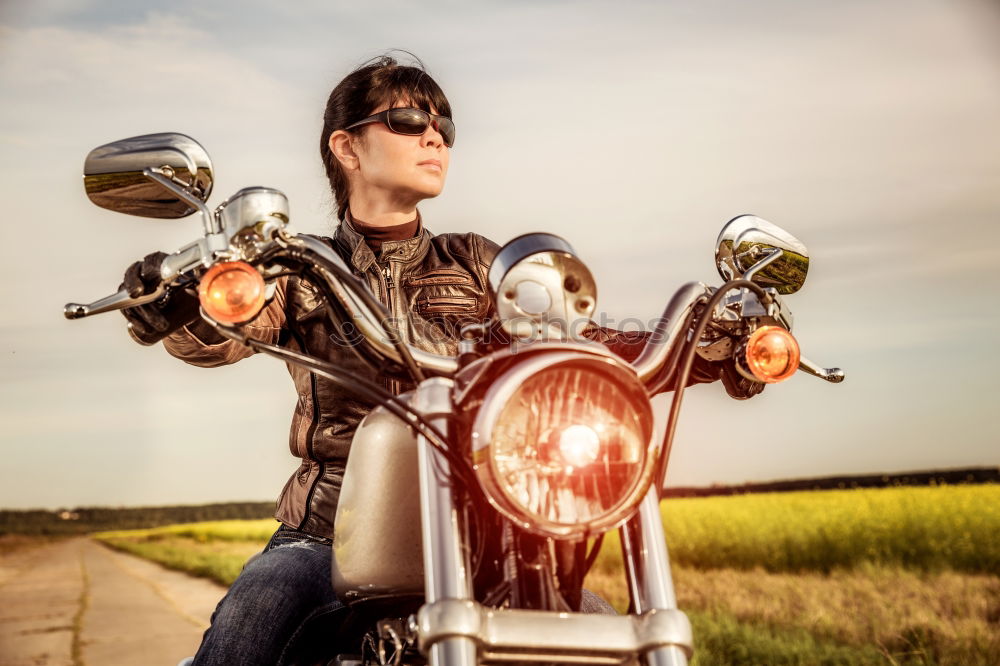 Similar – Long-haired brunette guy in sunglasses jeans and a jeans shirt posing on a black custom motorcycle