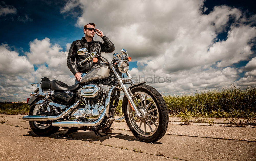 Similar – Long-haired brunette guy in sunglasses jeans and a jeans shirt posing on a black custom motorcycle