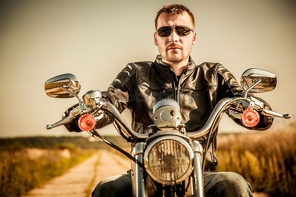 Similar – Long-haired brunette guy in sunglasses jeans and a jeans shirt posing on a black custom motorcycle