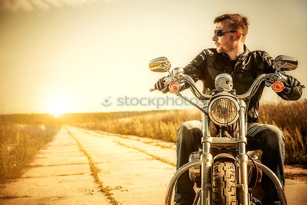 Similar – Long-haired brunette guy in sunglasses jeans and a jeans shirt posing on a black custom motorcycle