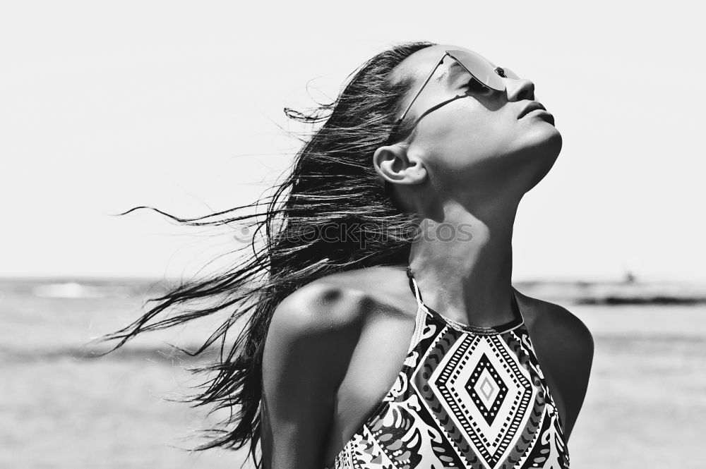 Similar – Cute woman touching her hair while the wind moves it.