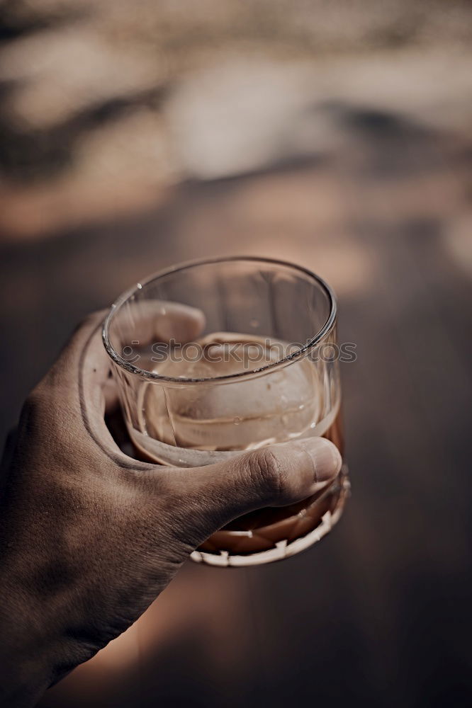 Similar – On a table there is a bottle of alcohol and a shot glass. A person’s hand is holding the shot glass.