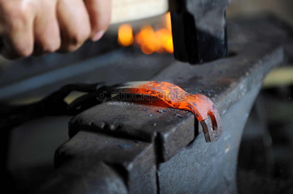 Similar – Blacksmith forges iron on anvil