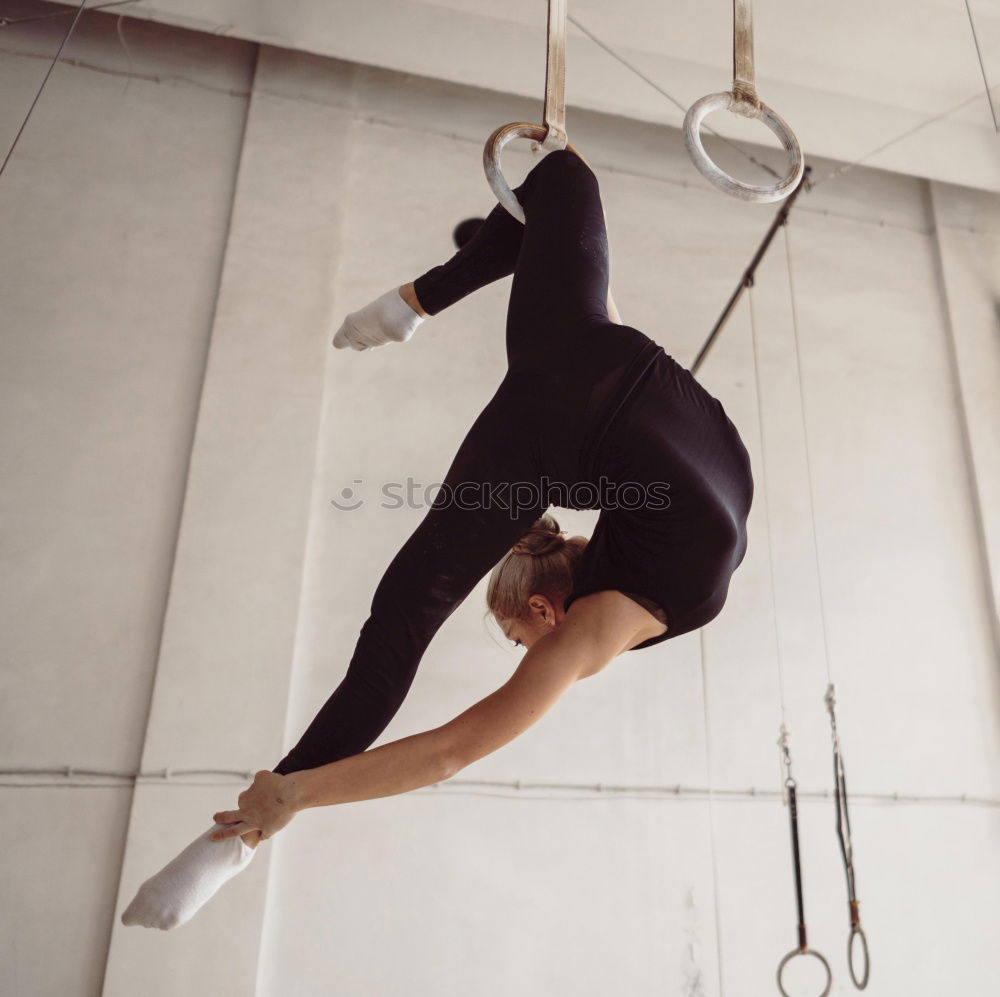 Athletic man balancing on gymnastic rings