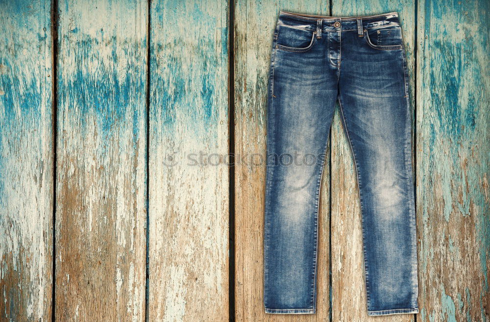 Similar – Blue jeans, boots with wooden smoking pipe