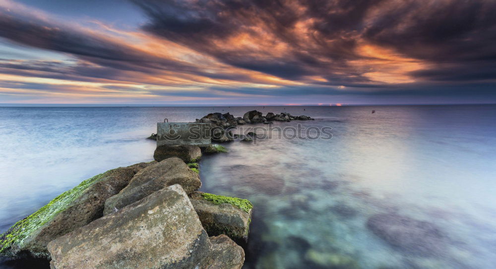 Similar – Rocks washed by the sea, with sky with sunset atmosphere