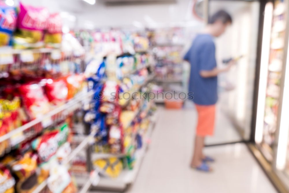 Similar – Image, Stock Photo A smiling middle aged woman in a light blue shirt is standing in a household section of a supermarket. She is holding a tablet and a red shopping basket in her hands. A woman is looking at the shelves, searching for something particular