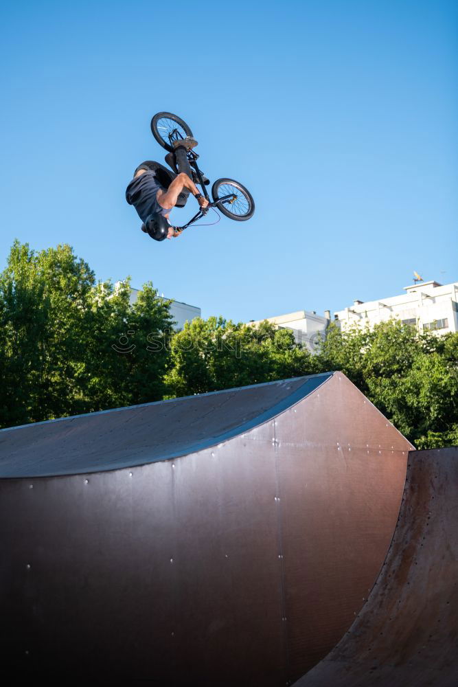 Girl on BMX bike in the air in halfpipe