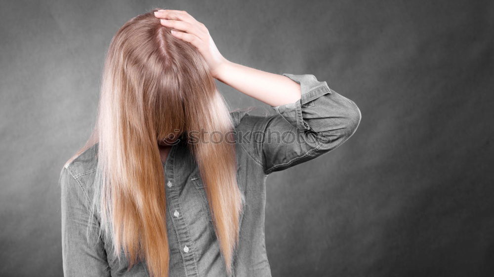 Similar – Portrait of a dark blond, long-haired woman looking into the camera through the hair on her face